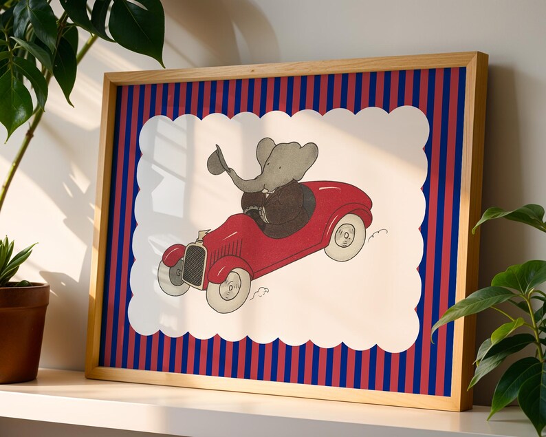 May include: Framed art print featuring a cartoon elephant driving a red vintage car. The artwork is set against a white background with a scalloped edge, framed by a striped pattern of red and blue, and a natural wood frame.