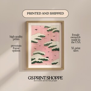 May include: Framed art print featuring a pink sky with white and green cloud formations and black birds. The print is in a light wood frame. Text on the image says "high quality prints", "premium frame options", and "XL print sizes". The print is from GS Print Shoppe.