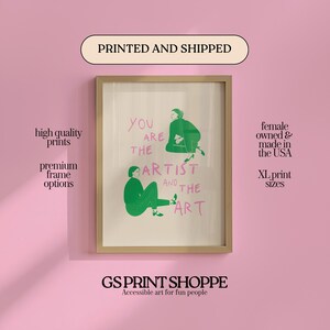 May include: A framed art print with the text "YOU ARE THE ARTIST AND THE ART" and illustrations of figures in green. The print is in a gold frame and is against a pink background. The text "GS PRINT SHOPPE" is at the bottom.