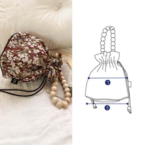 May include: A brown and white floral drawstring bag with a wooden bead handle. The bag is approximately 7 inches wide and 8 inches tall.
