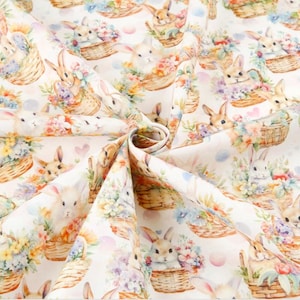 Może przedstawiać: Biała tkanina z powtarzającym się wzorem królików w koszykach wypełnionych kolorowymi kwiatami. Króliki są białe z różowymi noskami i wąsami.
