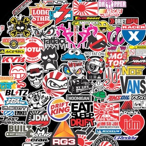 May include: A collection of colorful stickers with various logos and text, including "DRIFT KING," "JDM," and "VANS." The stickers are arranged in a circular pattern against a black background, featuring racing and automotive themes.