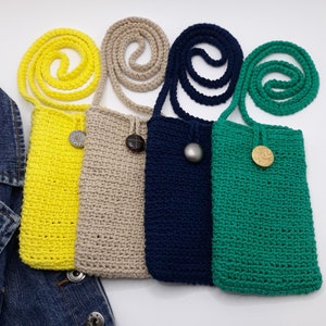 Crossbody phone bag has subtle raised close even stitches detailing each row. Feel soft and smooth. Top edging has a crochet button loop closure that loops around a 1 inch showy button sewn 1.5 inch from top edge. Same color strap display above bag.