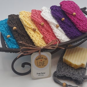 Soap Holder is a lacy feminine texture. Bags overlapped on black sleigh looking tray. Two crochet drawstrings same color as bag .5 inch from top of bag to cinch pouch shut. On end of each string a small wood bead. Handmade With Love sticker on bag.