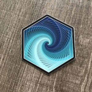 May include: A hexagonal sticker with a blue and white spiral design. The spiral is made up of many thin lines that create a sense of depth and movement.