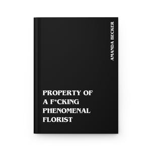 May include: A black hardcover journal with white text on the front cover that reads PROPERTY OF A F*CKING PHENOMENAL FLORIST. The name AMANDA BECKER is printed vertically in white text along the right side of the front cover of the book.
