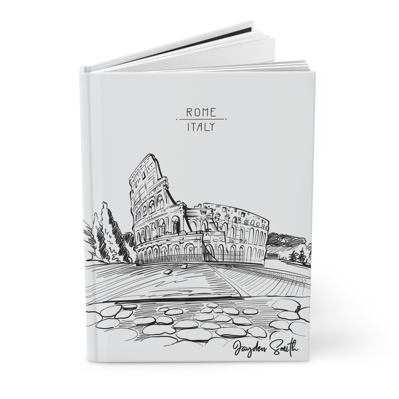Peut inclure: Un carnet blanc avec une illustration en noir et blanc du Colis&eacute;e &agrave; Rome, en Italie. Le texte "ROME ITALIE" est imprim&eacute; sur la couverture. Le carnet est sign&eacute; "Jayden Smith".