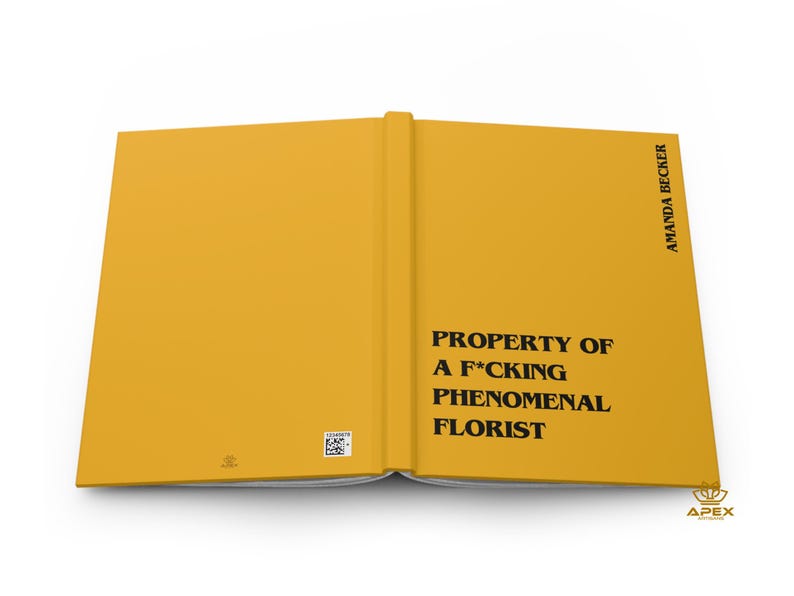 May include: A mustard yellow hardcover book laid open flat. The front cover features the black text PROPERTY OF A F*CKING PHENOMENAL FLORIST and the author name AMANDA BECKER. A small square barcode and a tiny logo are visible on the back cover.