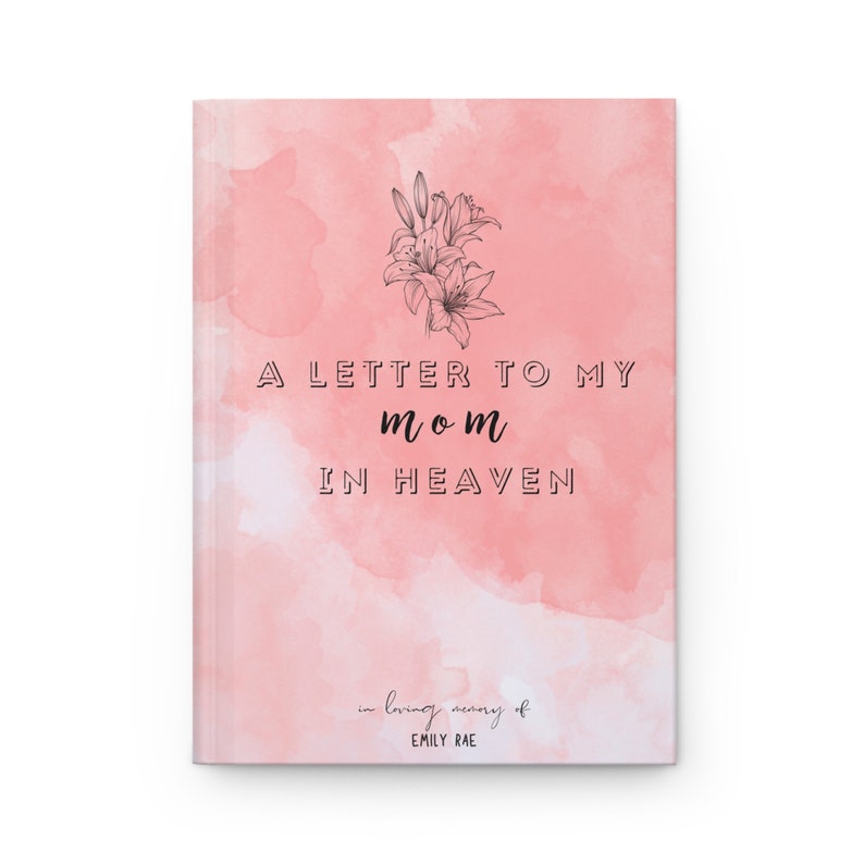 May include: A journal with a pink watercolor background featuring a black line drawing of lilies at the top. The text reads A LETTER TO MY mom IN HEAVEN and at the bottom in loving memory of EMILY RAE. The cover has a soft, blended aesthetic.