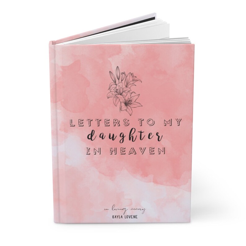 May include: A pink watercolor book cover with a floral design and the text "Letters to my daughter in heaven" in black lettering. The text "in loving memory" and "KAYLA LOVENE" are also included in black lettering.