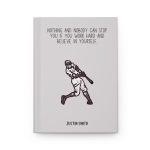 May include: A gray journal with the text "NOTHING AND NOBODY CAN STOP YOU IF YOU WORK HARD AND BELIEVE IN YOURSELF." and a baseball player illustration. The name "JUSTIN SMITH" is printed at the bottom.