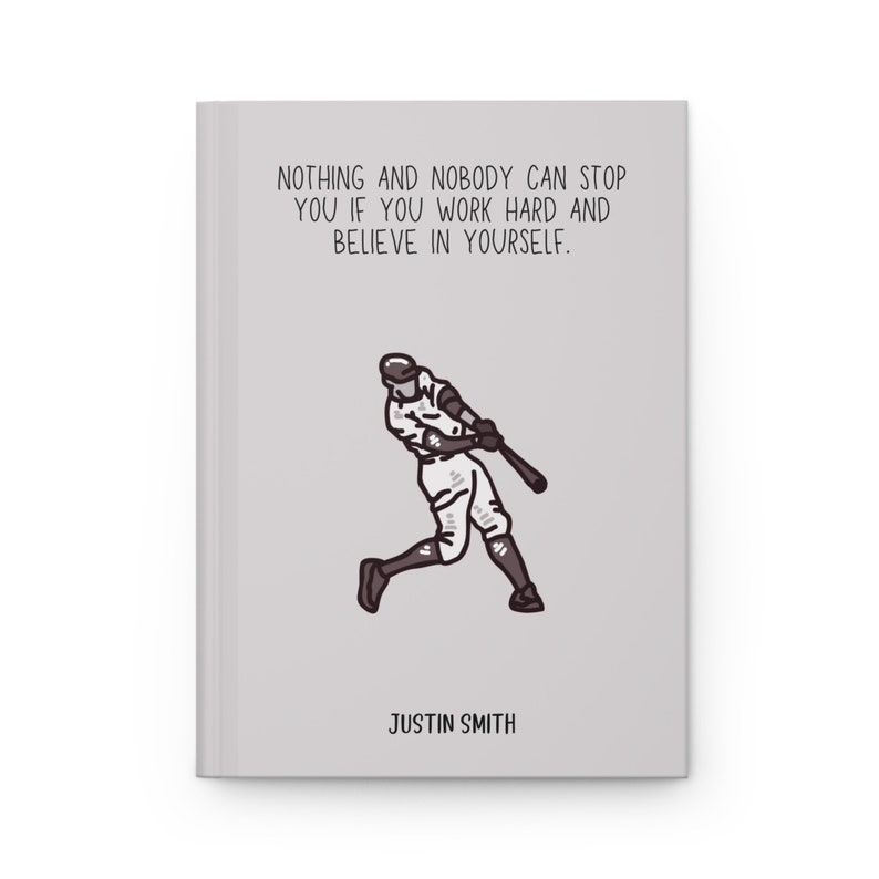 May include: A gray journal with the text "NOTHING AND NOBODY CAN STOP YOU IF YOU WORK HARD AND BELIEVE IN YOURSELF." and a baseball player illustration. The name "JUSTIN SMITH" is printed at the bottom.