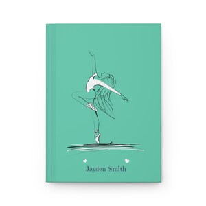 May include: A teal hardcover journal featuring a black and white line art illustration of a ballet dancer in a pose. Below the dancer, the text "Jayden Smith" is printed in a dark gray font, flanked by two small white heart icons.