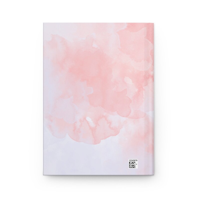 May include: A softcover notebook with a pink watercolor design on the cover. The design features light pink and white watercolor washes that blend together.