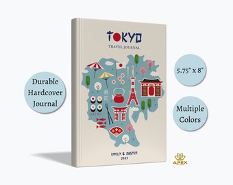 May include: A beige hardcover travel journal measuring 5.75 inches by 8 inches. The cover features the text TOKYO TRAVEL JOURNAL, EMILY & JUSTIN 2023, and colorful illustrations of Japanese landmarks, sushi, a red teapot, and a torii gate.