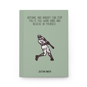 May include: A sage green journal with the text "NOTHING AND NOBODY CAN STOP YOU IF YOU WORK HARD AND BELIEVE IN YOURSELF." A baseball player illustration is featured below the text. The name "JUSTIN SMITH" is printed at the bottom.