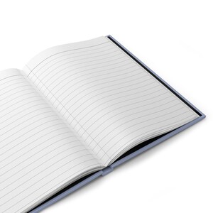 May include: Open notebook with lined pages. The notebook has a light blue cover and a black spine. The pages are white with gray lines, perfect for writing or journaling. The notebook is open, displaying the interior pages.