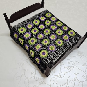 1:12 scale crochet dollhouse blanket made from multicolored granny squares on a black basе, miniature bedspread for collectors, afghan sofa