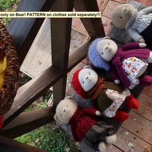 Peut inclure: Plusieurs ours en peluche crochet&eacute;s v&ecirc;tus de diff&eacute;rentes tenues, dont un pull rouge, un manteau violet et un chapeau bleu. Les ours sont pos&eacute;s sur une surface en bois. Le texte de l'image indique : "PATTERN only on Bear! PATTERN on clothes sold separately!!!".