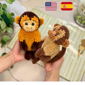 May include: Two handmade crochet monkey plush toys made from soft, textured yarn. One monkey is primarily golden-yellow with dark brown accents on the head, ears, and paws. The second monkey is light beige with dark brown head and limb details.