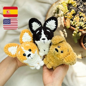 May include: Three crocheted stuffed animal dogs. One is black and white, one is yellow, and one is orange and white.