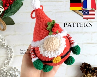 Puede incluir: Adorno de gnomo de Papá Noel tejido a crochet. El gnomo tiene un gorro rojo con pompón y ribete blancos, barba beige y cuerpo rojo con ribete blanco. Los brazos y pies del gnomo son verdes. La palabra "PATTERN" es visible.