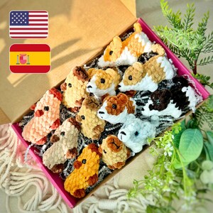 May include: A selection of crochet animal figures in a box. The handmade toys are in shades of orange, brown, white, and grey. The box has a pink lining and is filled with decorative paper. The box is open, revealing the contents.