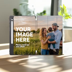 May include: A black tablet case with a stylus holder, featuring a customizable cover. The left side displays the white text "YOUR IMAGE HERE" and "Please, send me your photo" over a grassy field. The right side shows a family photo.