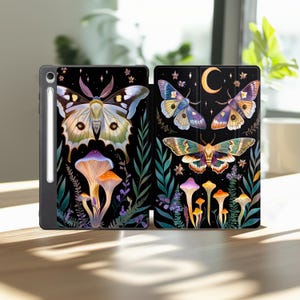 May include: Black tablet case with a colorful illustration of moths, mushrooms, and foliage. The design features a large moth with intricate wing patterns, alongside vibrant mushrooms and greenery. The case is open, revealing the tablet screen.
