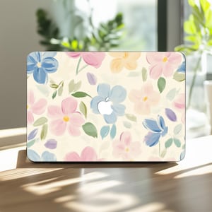 以下が含まれることがあります： パステルカラーの花柄が特徴のノートパソコンカバー。青、ピンク、黄色の花と緑の葉がクリーム色の背景に描かれています。Appleのロゴが見えます。