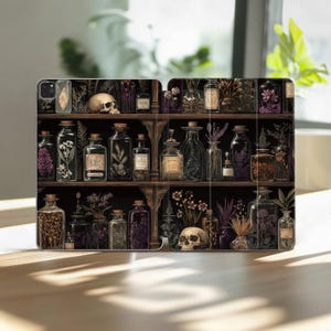 Puede incluir: Funda para tableta con una ilustración detallada de una estantería de madera oscura llena de botellas de boticario, tarros y una calavera. Las botellas contienen varias hierbas y flores, con una paleta de colores de marrones, morados y verdes.