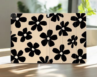 May include: A tablet case featuring a repeating pattern of solid black, five-petaled flowers set against a light beige background. The case is shown in an open, unfolded position, displaying the full exterior design and the camera cutout.