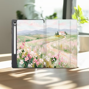 May include: A black tablet case and a tablet cover with a landscape painting. The painting depicts a Tuscan countryside scene with a winding road, a house, and fields of pink and white flowers.
