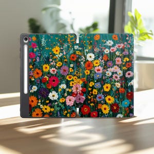 Può includere: Una custodia per tablet con un vivace design floreale. La custodia presenta una colorata serie di fiori nei toni del rosso, giallo, rosa e bianco su uno sfondo turchese. Uno stilo è attaccato al lato della custodia.