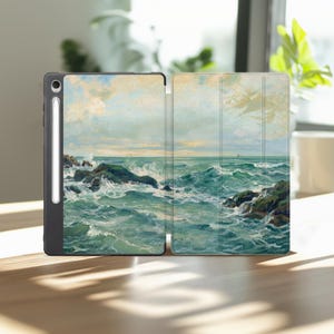 May include: A black tablet case featuring a printed seascape painting of crashing ocean waves against dark rocks under a cloudy sky. The case includes a dedicated vertical slot on the left side containing a white stylus pen for the device.