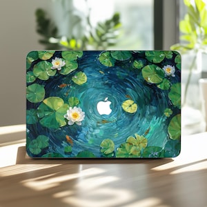 May include: Laptop case featuring a vibrant pond scene with lily pads, white water lilies, and small orange fish. The design has a swirling water effect with a white Apple logo in the center. The case is on a wooden surface.