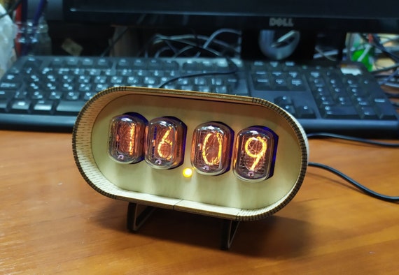 Real Soviet-era IN-12 nixie tubes glow inside a handcrafted wooden case — analogue warmth meets Cold War tech in a desk clock nobody else owns.