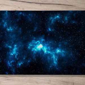 以下が含まれることがあります： 青と黒の色合いで描かれた星雲の鮮やかな描写が特徴のタブレットケース。白い星が散りばめられ、宇宙をテーマにしたデザインです。ケースは長方形で、角は丸みを帯びています。