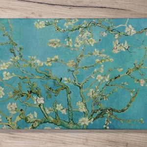 May include: A painting of a blooming almond tree with white flowers against a blue sky. The branches of the tree are depicted in a thick, textured style, with visible brushstrokes. The painting is in a style reminiscent of Vincent van Gogh.