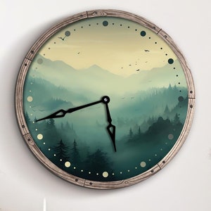 Puede incluir: Un reloj redondo de madera con una escena de bosque brumoso y una esfera negra. El reloj está colgado en una pared blanca sobre una estantería de madera con tres cajones.