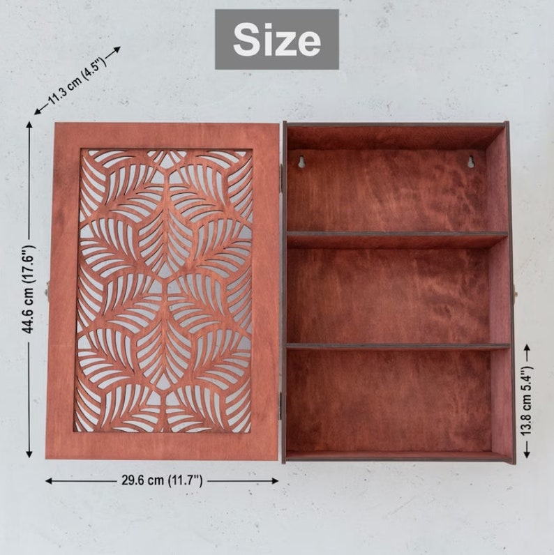 May include: A wooden wall cabinet with a decorative leaf pattern on the door. The cabinet has three shelves and measures 17.6 inches tall, 11.7 inches wide, and 5.4 inches deep.