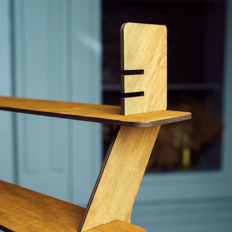 May include: A wooden shelf unit with three shelves. The shelves are made of light brown wood and have a natural finish. The unit is designed to be wall-mounted and has a modern, minimalist style.
