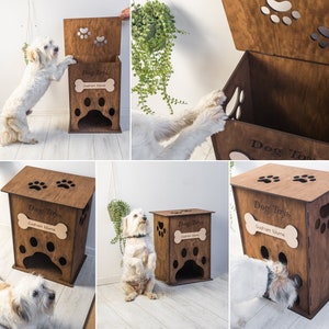 May include: A wooden dog toy box with paw print cutouts and the words "Dog Toys" and "Custom Name". The box is brown and has a bone-shaped name tag. A small white dog interacts with the box.