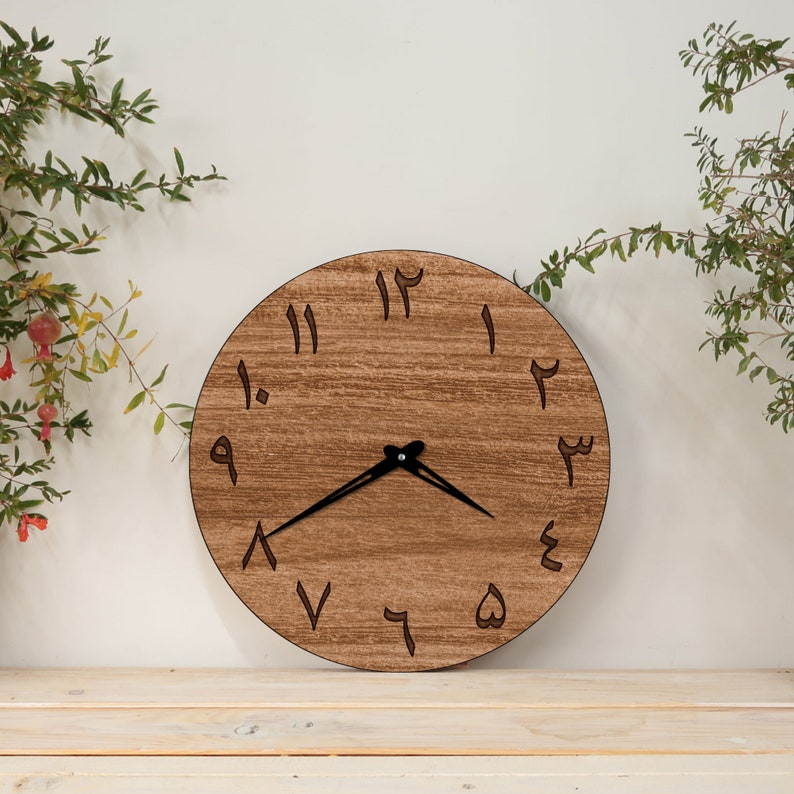 May include: A round wooden clock with Arabic numerals, a black hour and minute hand, and a brown wood grain finish.