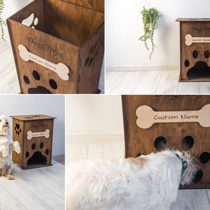 May include: A wooden dog toy storage box with paw-shaped cutouts and a bone-shaped name tag. The box is engraved with "Dog Toys" and "Custom Name". The box is brown and has a rectangular shape.