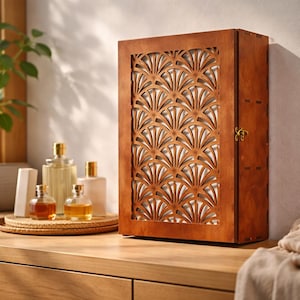 May include: A brown wooden cabinet with a decorative, fan-shaped cutout design on the front. The cabinet has a small brass clasp. Several glass bottles of perfume and toiletries are visible on a nearby wooden surface.