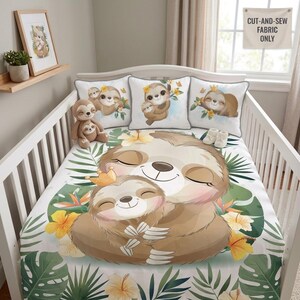 May include: A white crib bedding set featuring a large illustration of a mother sloth holding a baby sloth with a gold crown, surrounded by green tropical leaves and yellow hibiscus flowers. Includes three square pillows with sloth graphics.