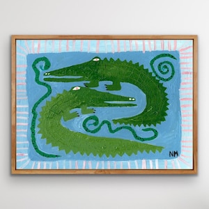 Könnte beinhalten: Originalgemälde mit zwei grünen Alligatoren auf blauem Hintergrund. Die Alligatoren sind im Folk-Art-Stil mit strukturierten Pinselstrichen gemalt. Das Gemälde ist in einem Naturholzrahmen gerahmt und hat einen hellblauen und rosa Rand.