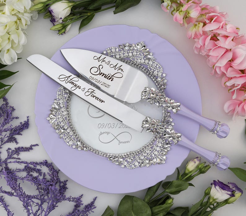 May include: A lavender cake server set with a silver knife and server. The knife has the text "Always & Forever" and the server has the text "Mr. & Mrs. Smith 09/03/2025".