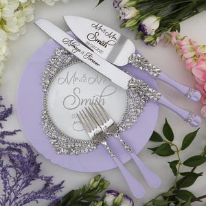 May include: A set of wedding cake cutting knives and forks with lavender handles. The knives are engraved with "Mr. & Mrs. Smith 09.03.2025 Always & Forever" and the forks are engraved with "Always & Forever".